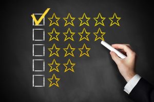 hand drawing golden rating stars on a black chalk board