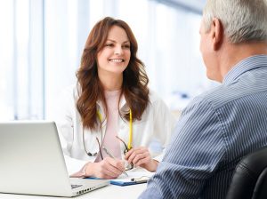 Portrait of female doctor consulting her older patient at hospital.
